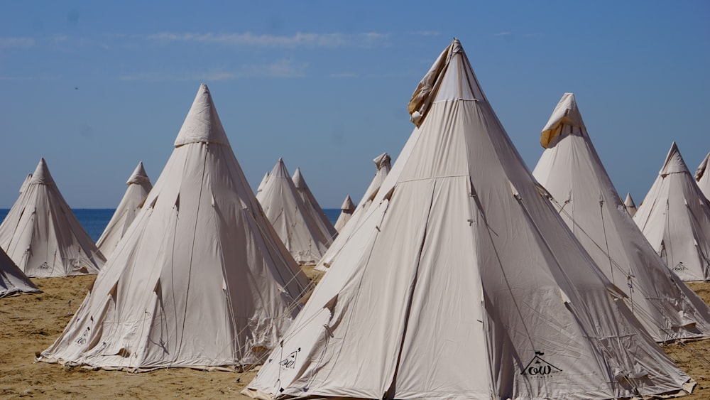 white tent on brown sand under blue sky during daytime