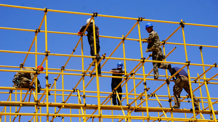 Scaffolders assembling a large tube-and-fitting structure