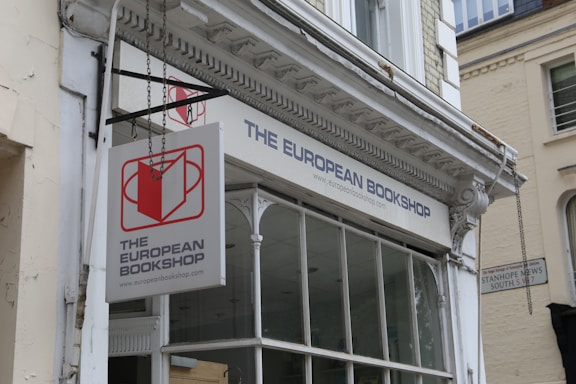 A welcoming bookstore storefront with red and white signage under a bright sky.