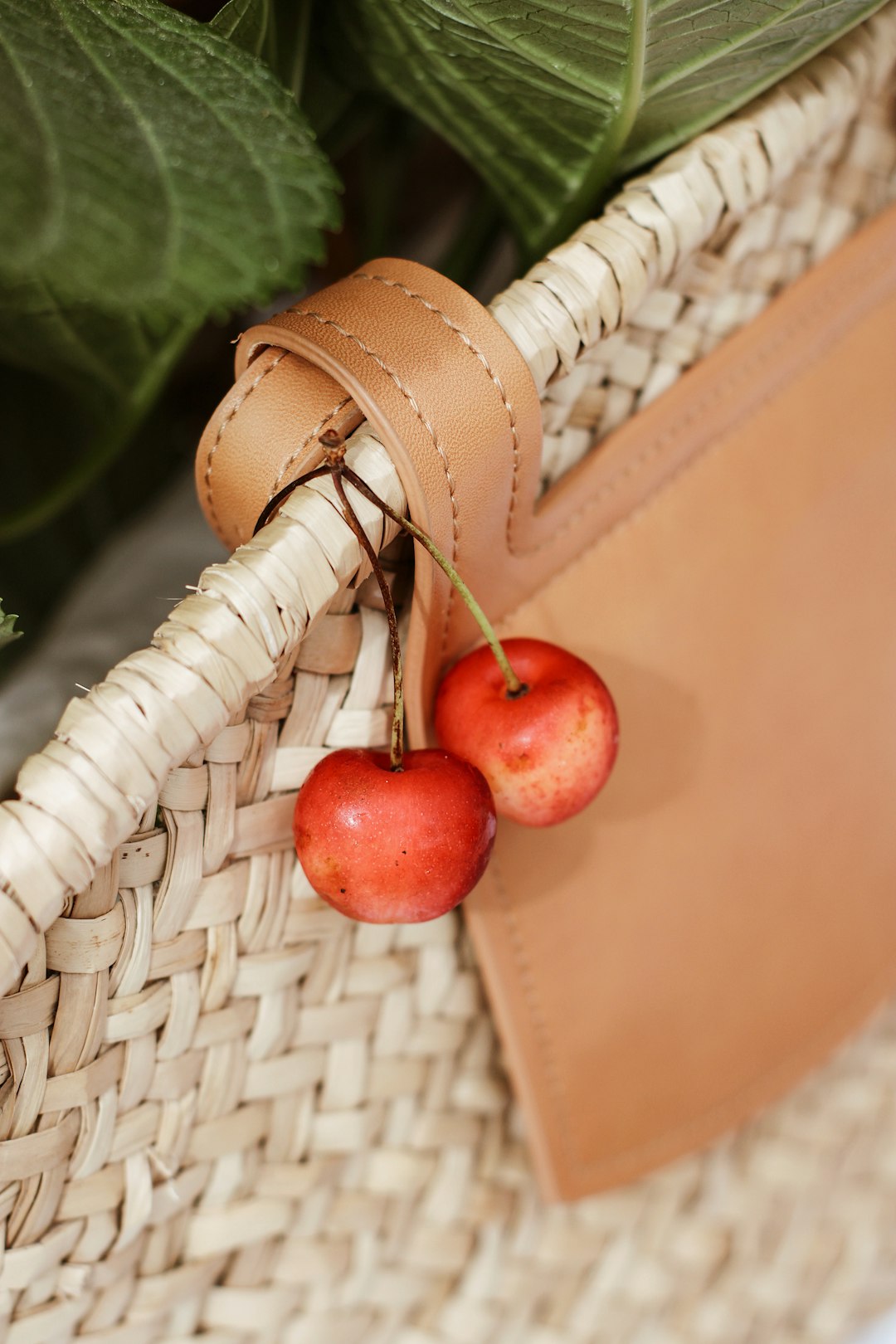 red cherries on brown woven basket