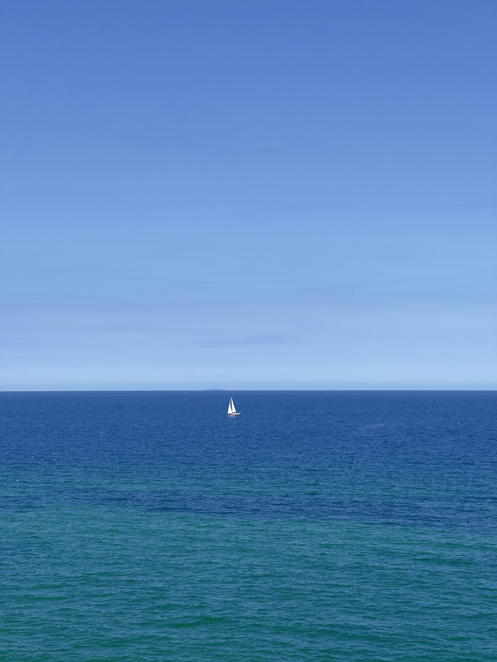 white sailboat on blue sea under blue sky during daytime