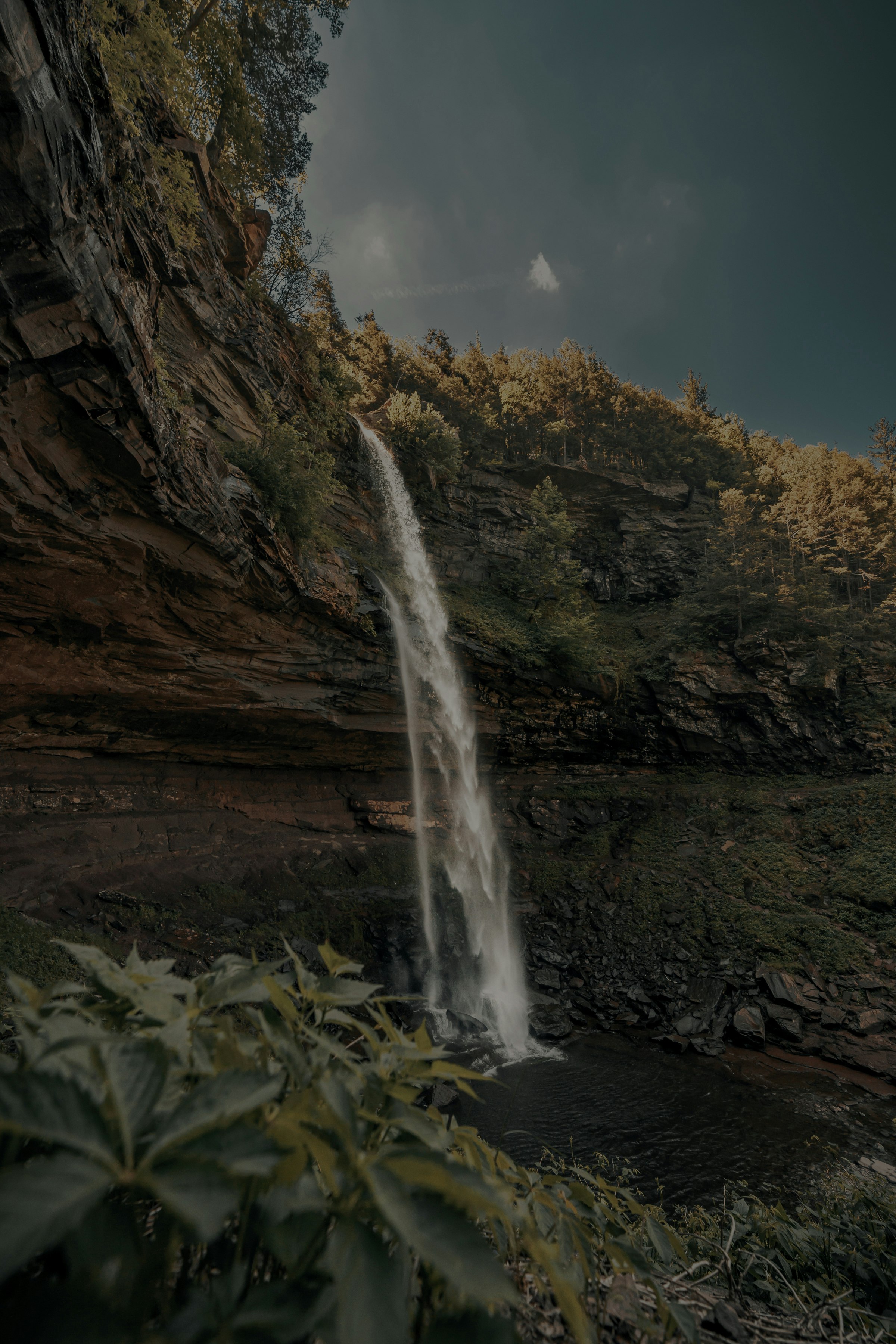 waterfalls on brown rocky mountain under blue sky during daytime