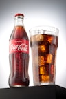 coca cola bottle beside drinking glass