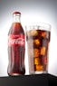 coca cola bottle beside drinking glass