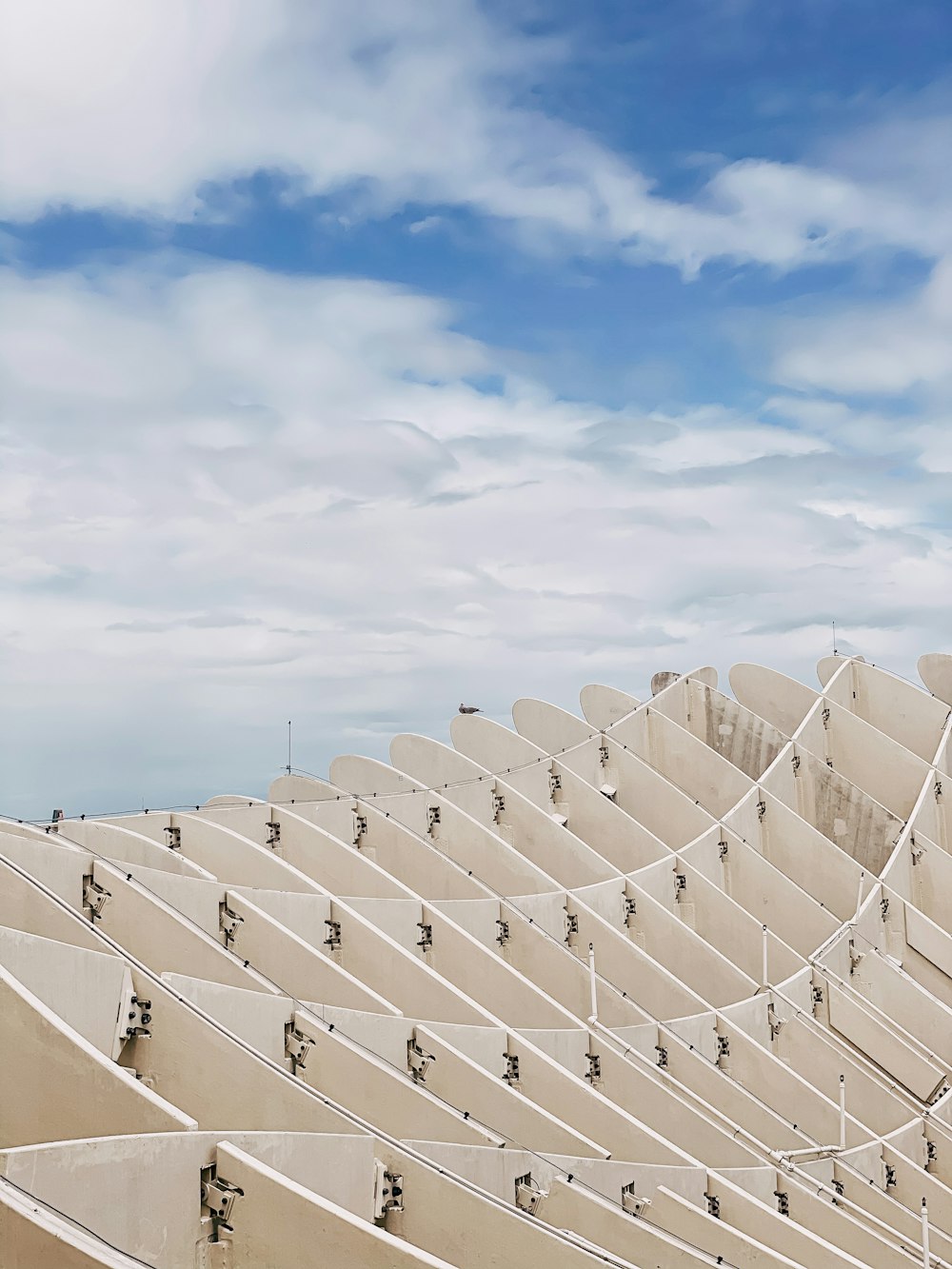 a row of white benches sitting on top of a sandy beach
