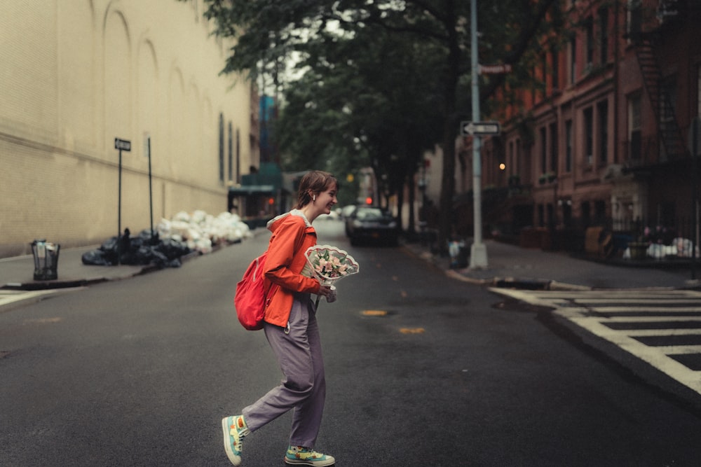 man in red hoodie and brown pants running on street during daytime