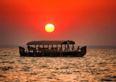 silhouette of boat on sea during sunset