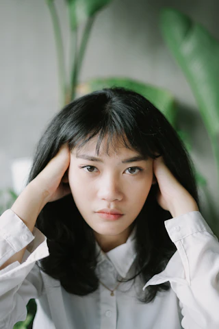 두 손으로 머리를 감싼 여성