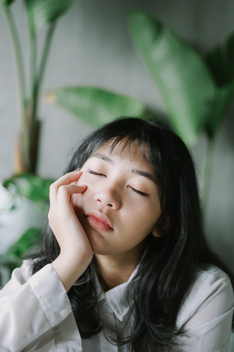 눈을 감고 볼을 감싼 여성