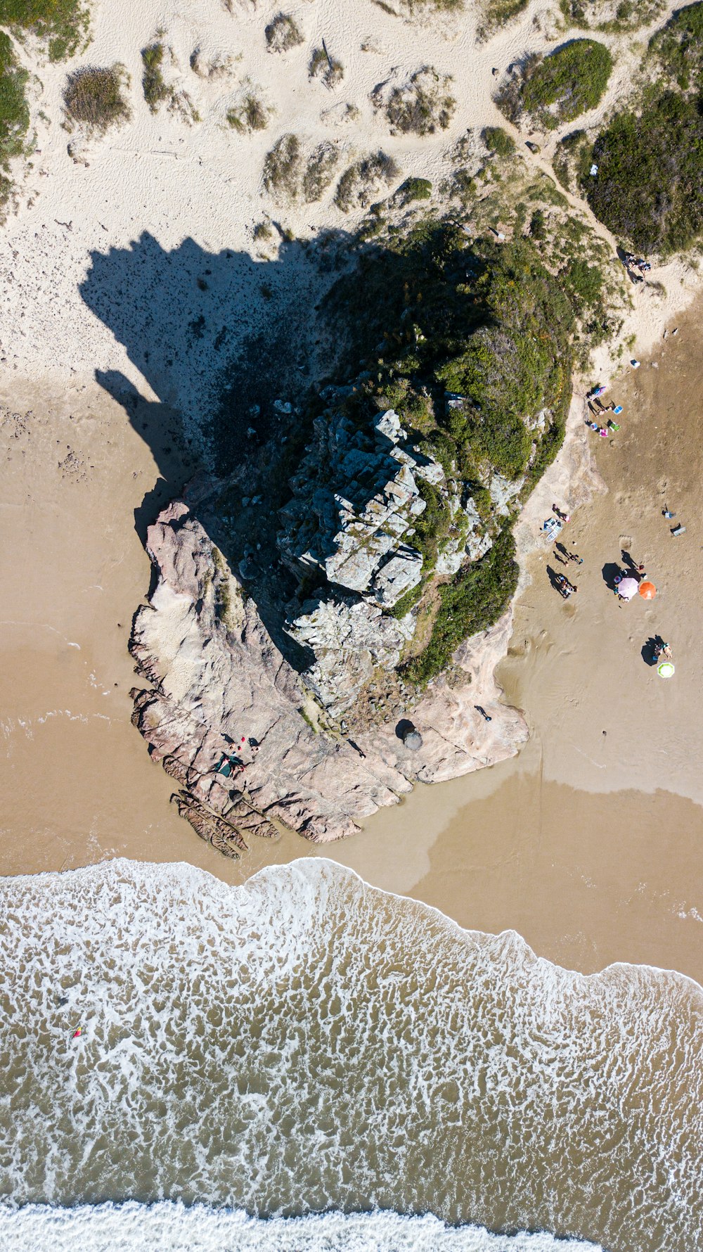 person in black shirt and black pants sitting on rock formation during daytime