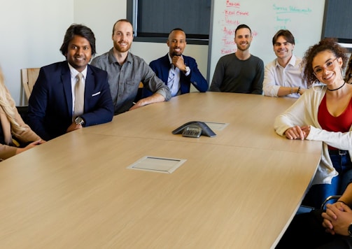 group of people sitting on chair in front of brown wooden table