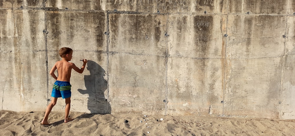 person in gray jacket standing on brown sand during daytime