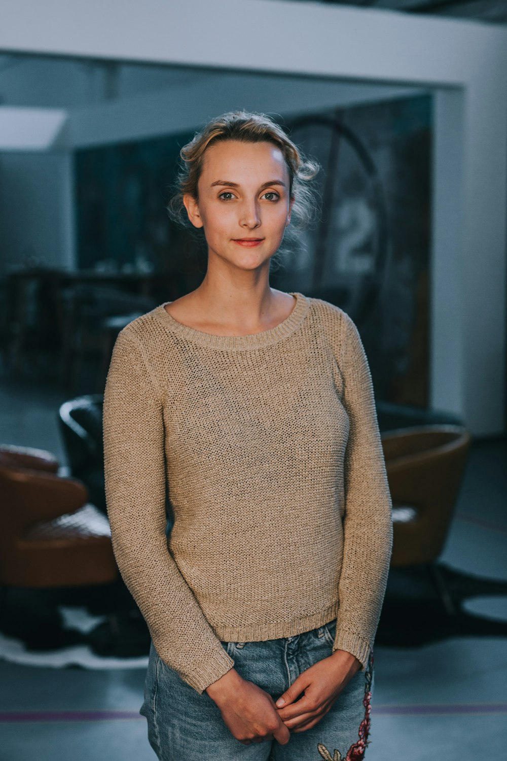 woman in brown sweater standing