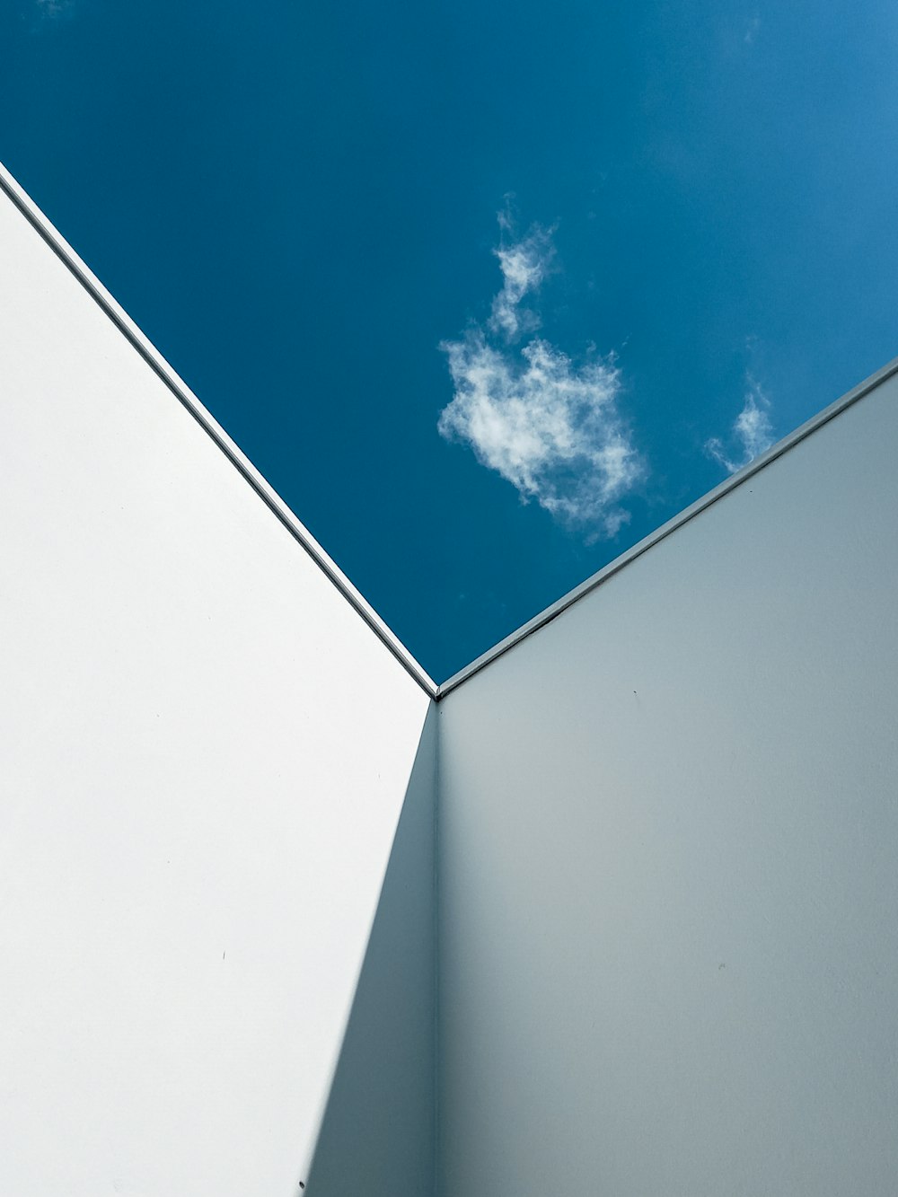 white concrete building under blue sky and white clouds during daytime