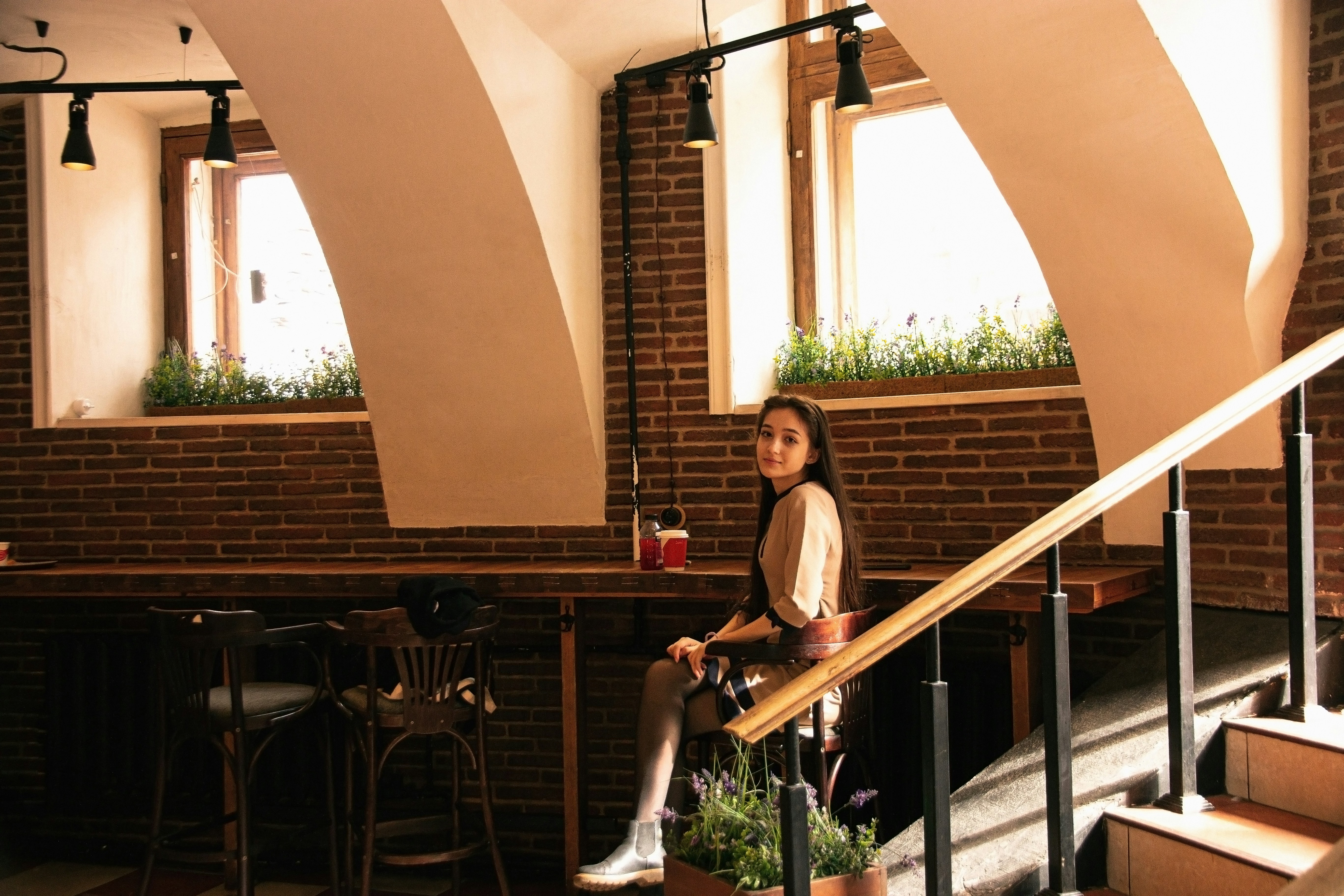 woman in white t-shirt and white pants standing on balcony during daytime
