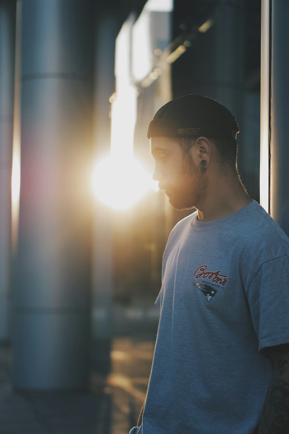 man in white crew neck t-shirt standing near glass window