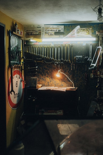 A craftsman assembling a vibrant illuminated sign in a workshop filled with tools and materials.