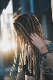 woman in black long sleeve shirt covering her face with her hair