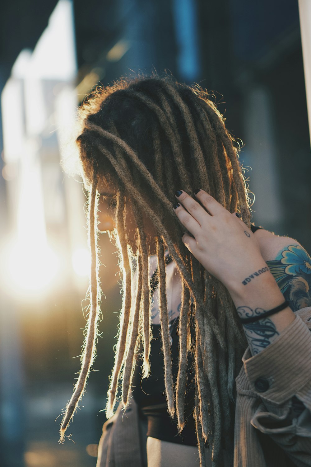 woman in black long sleeve shirt covering her face with her hair