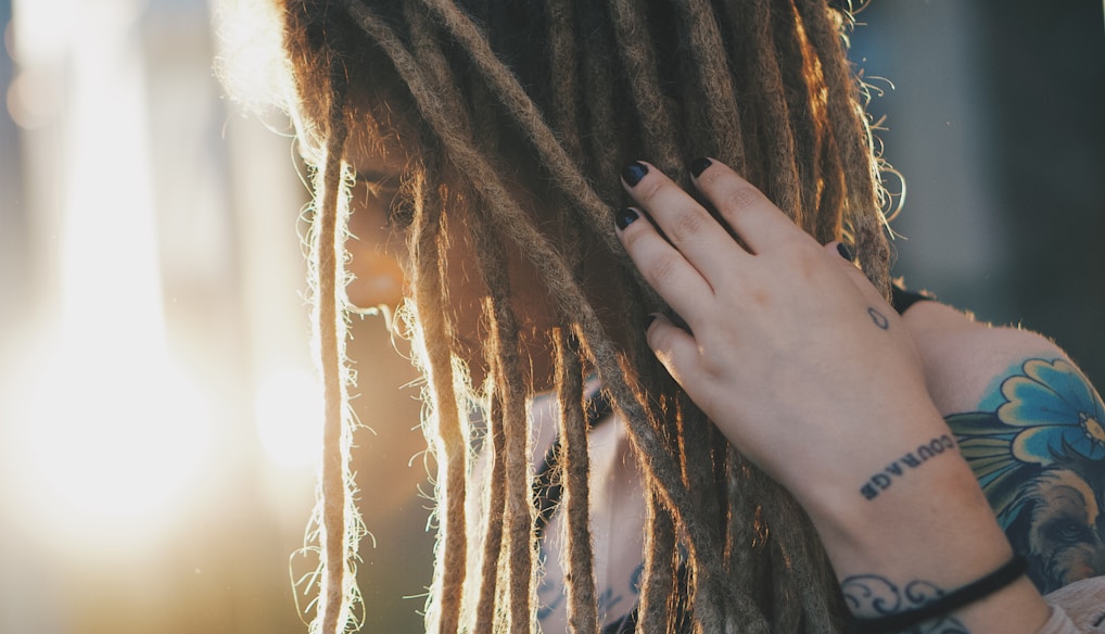 woman in black long sleeve shirt covering her face with her hair