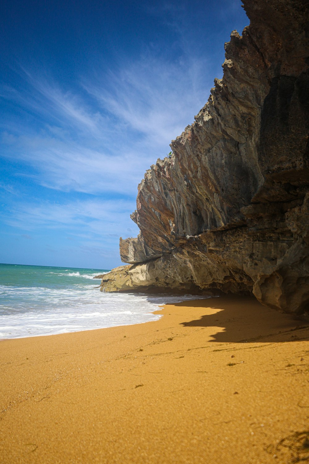 brown rock formation near body of water during daytime