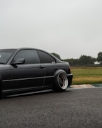 black sedan on gray asphalt road during daytime