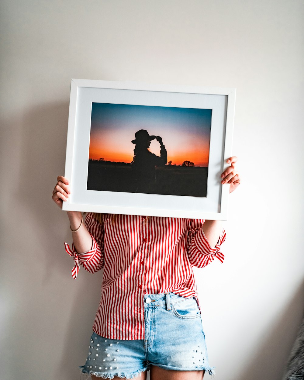 woman in red and white stripe long sleeve shirt and blue denim shorts