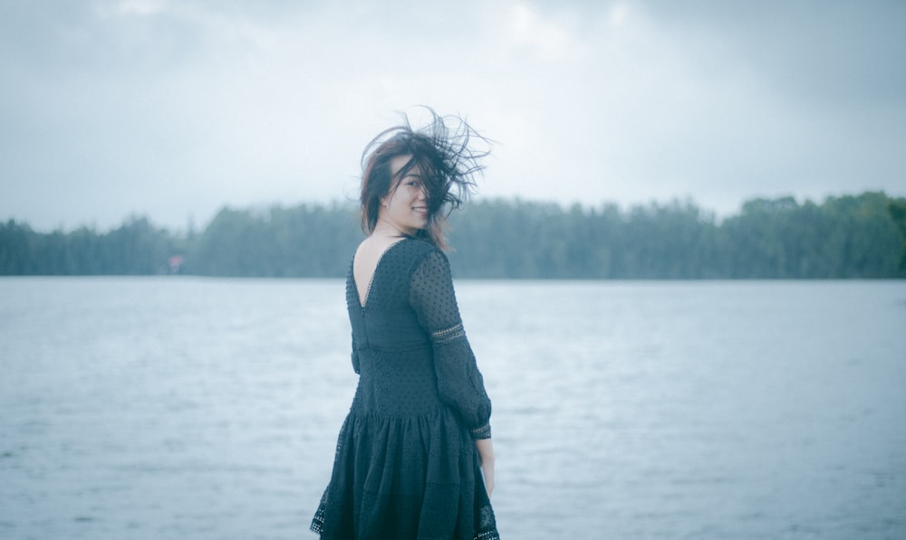 woman in black dress standing on water