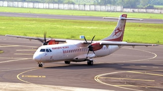 white and red passenger plane on airport during daytime