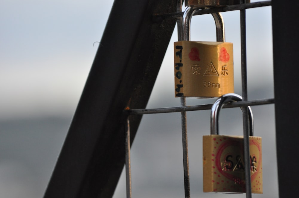 gold padlock on black metal bar