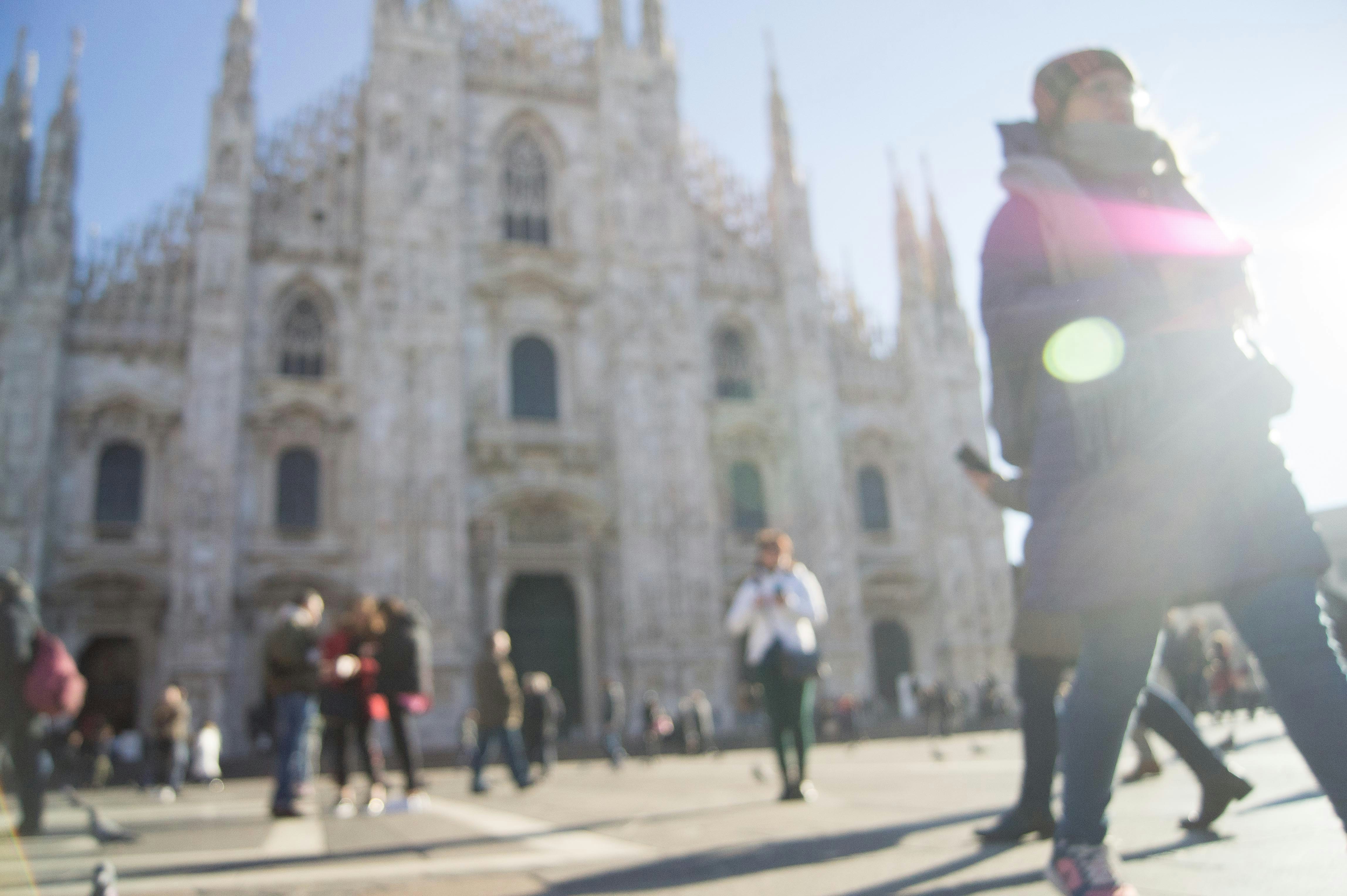 Menschen, die tagsüber auf der Straße in der Nähe des weißen Betongebäudes spazieren gehen