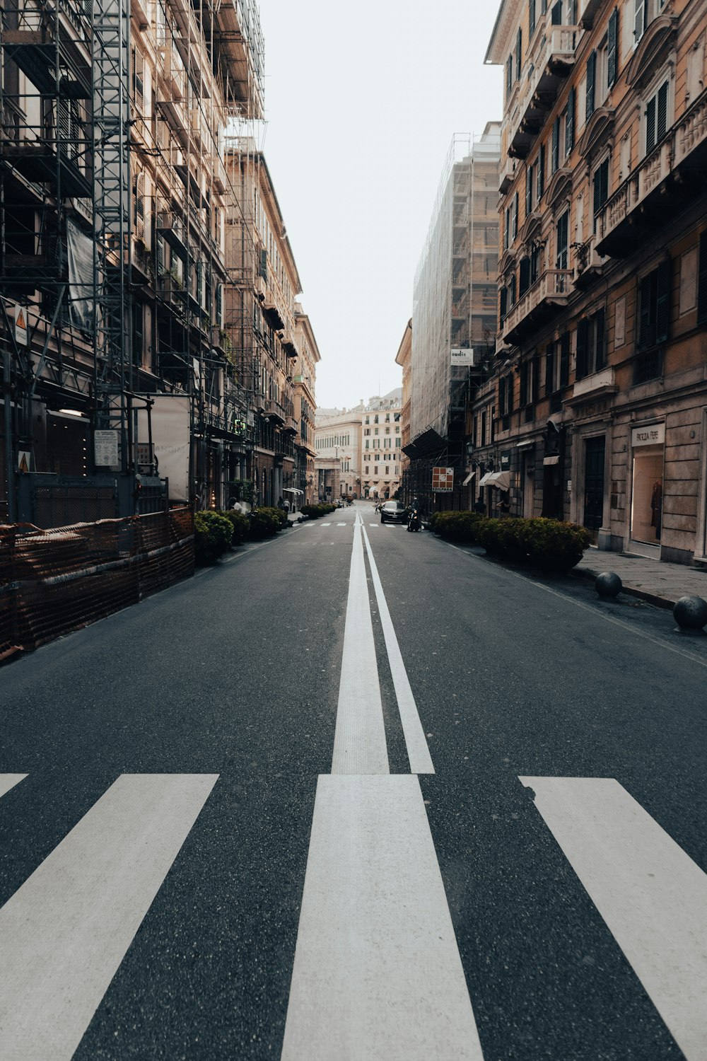 gray asphalt road between brown concrete buildings during daytime