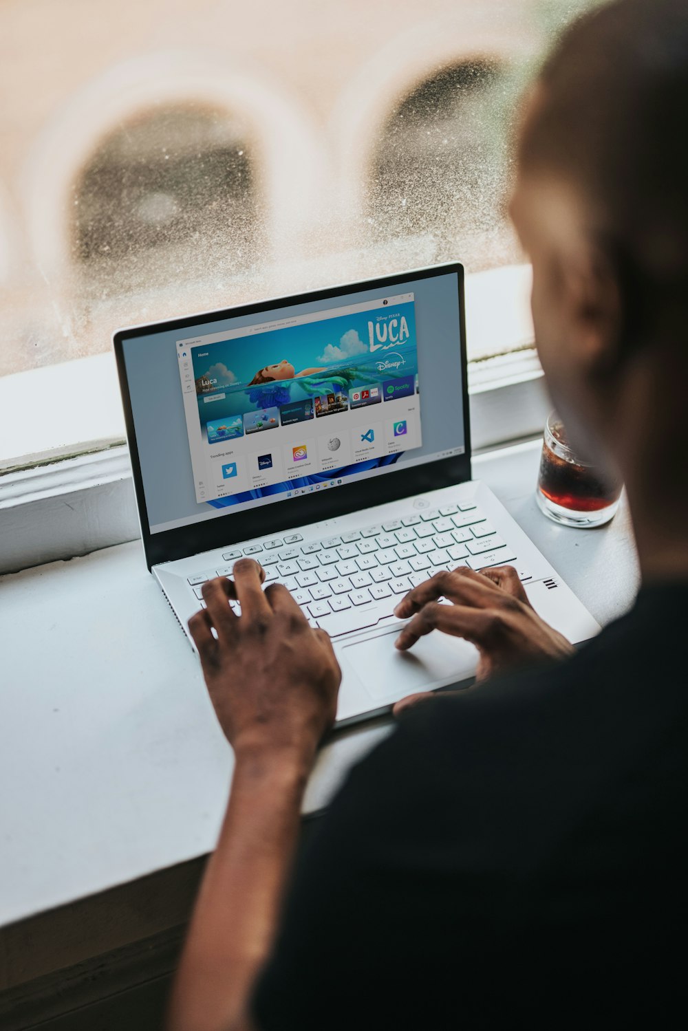 person using macbook pro on white table