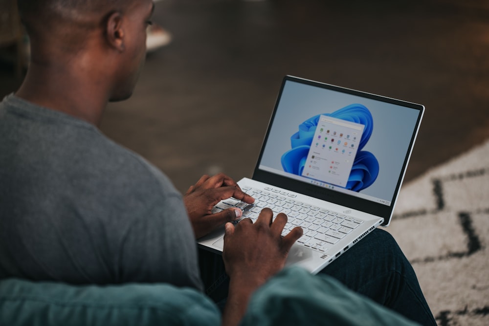 man in gray long sleeve shirt using Windows 11 computer