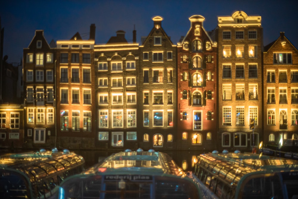 cars parked in front of brown building during night time