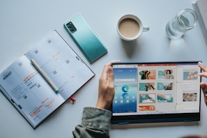 person using Windows 11 computer beside white ceramic mug on white table