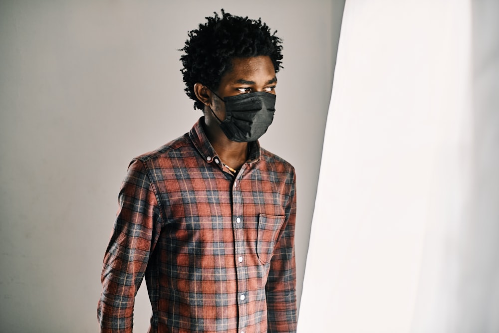 homme en chemise à carreaux noir et blanc portant des lunettes noires