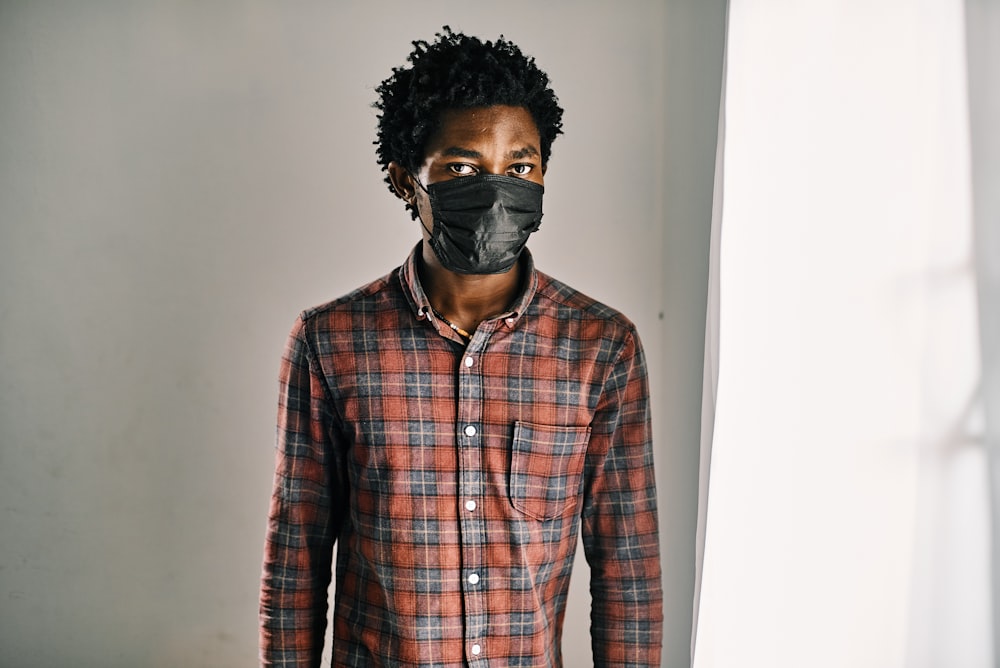 homme en chemise à carreaux rouge, bleu et blanc portant des lunettes noires