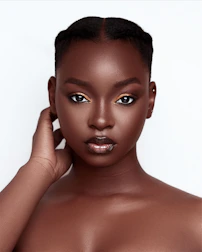 Close-up of a confident woman smiling with subtle, alluring makeup