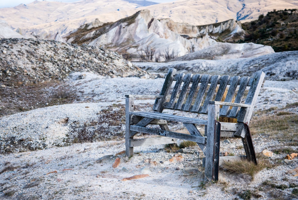 brown wooden bench on white snow covered ground during daytime