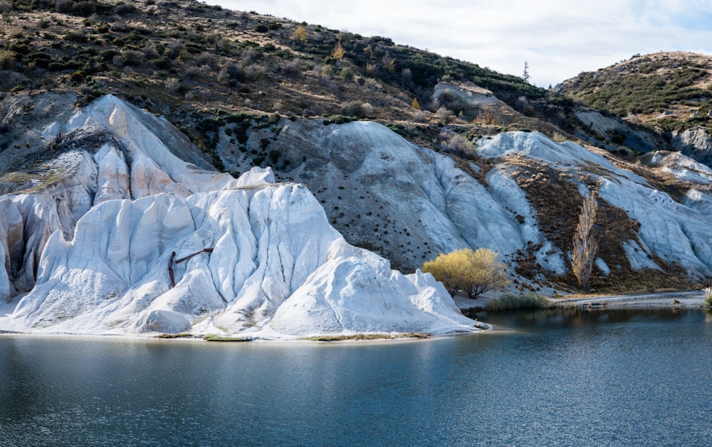 white and brown mountain near body of water during daytime