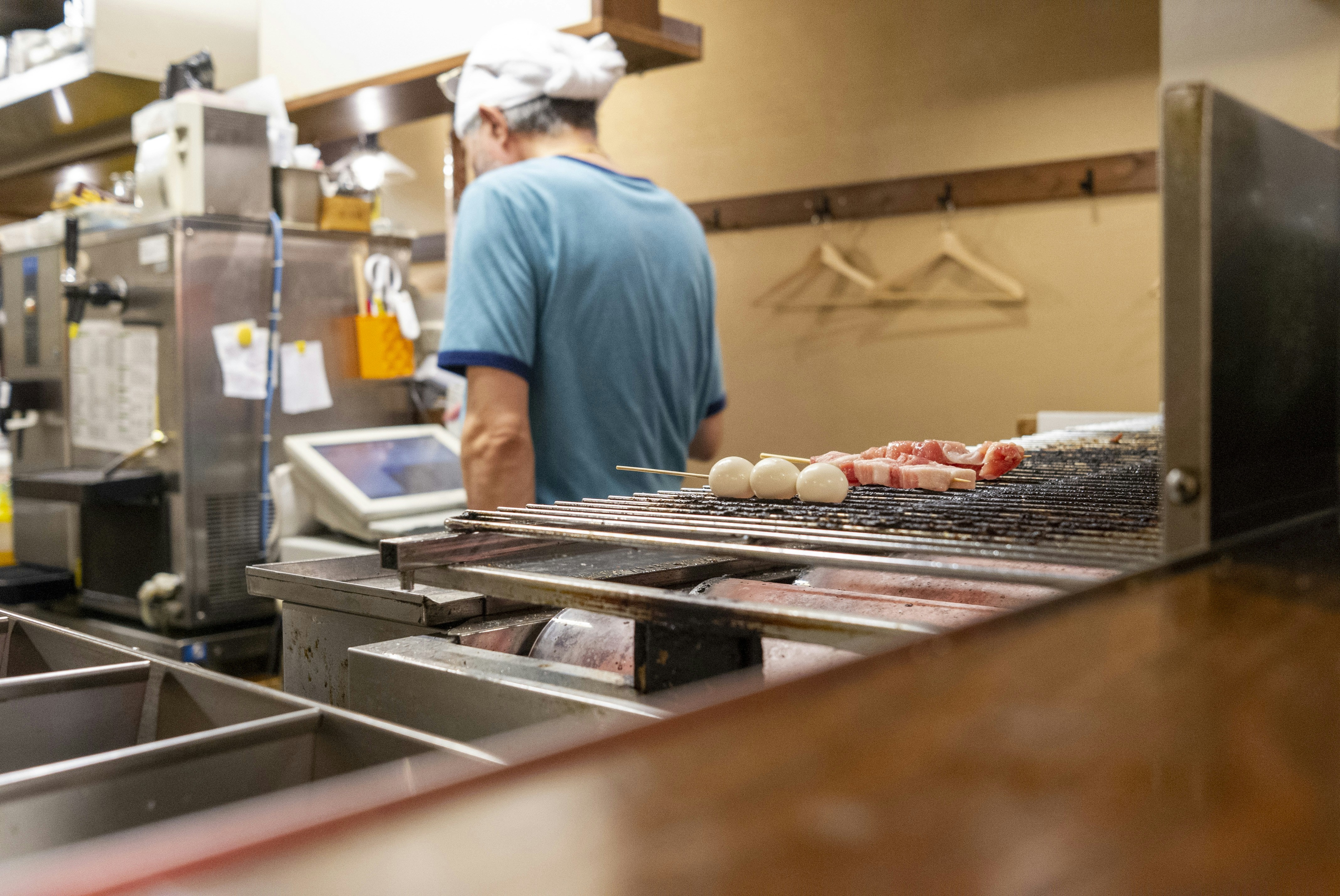 man in blue shirt standing in front of food display counter
