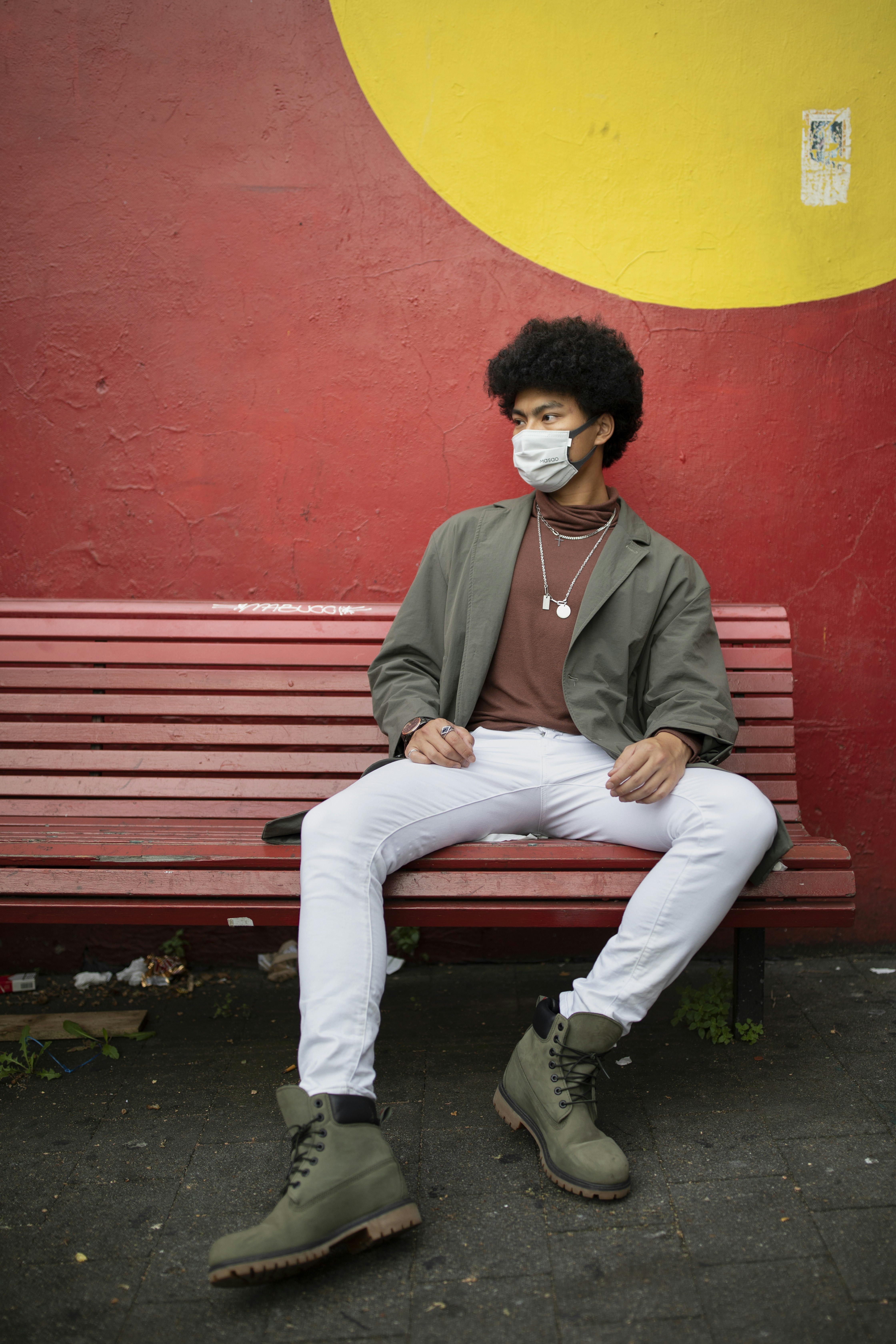 man in red blazer sitting on red bench
