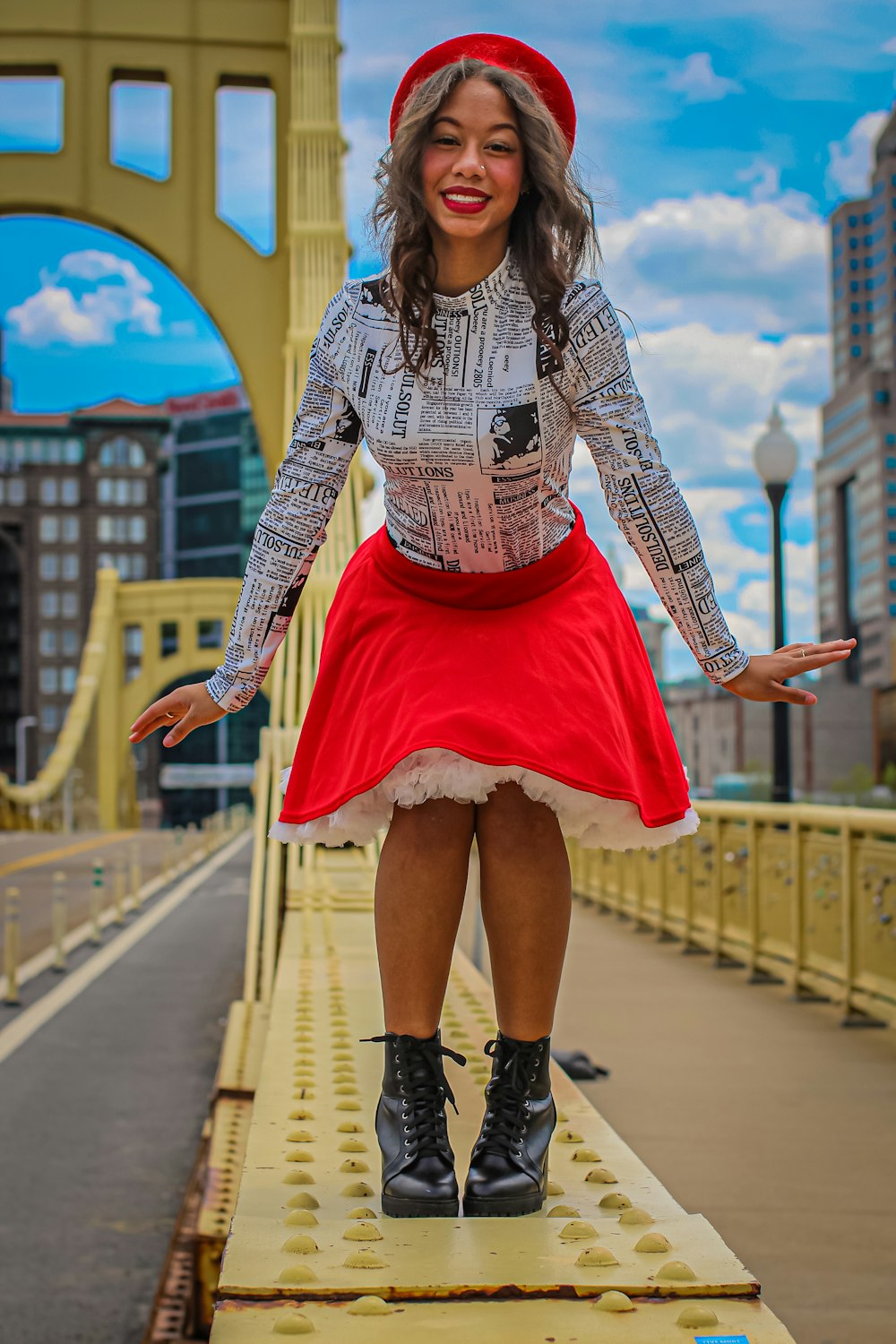 woman in white and black long sleeve shirt and pink skirt standing on bridge during daytime