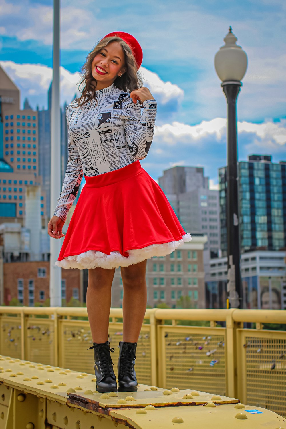 woman in white and black dress standing on brown wooden fence during daytime