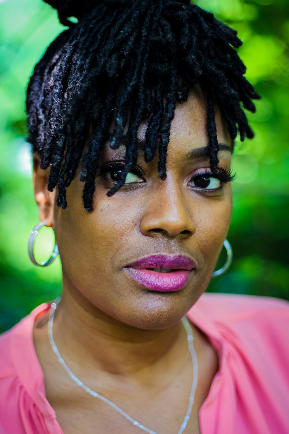 woman in pink shirt with black braided hair