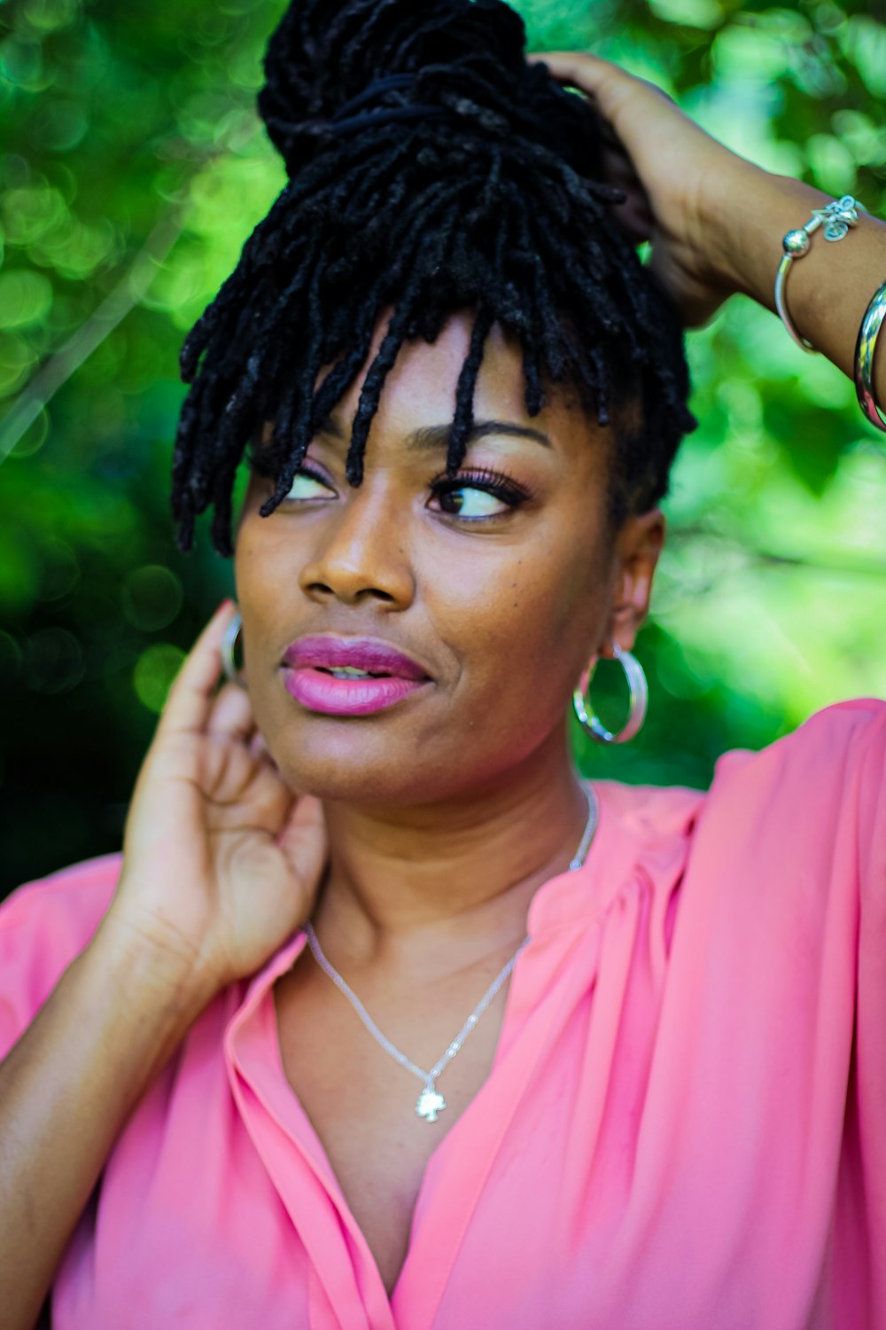 woman in pink shirt wearing white earbuds