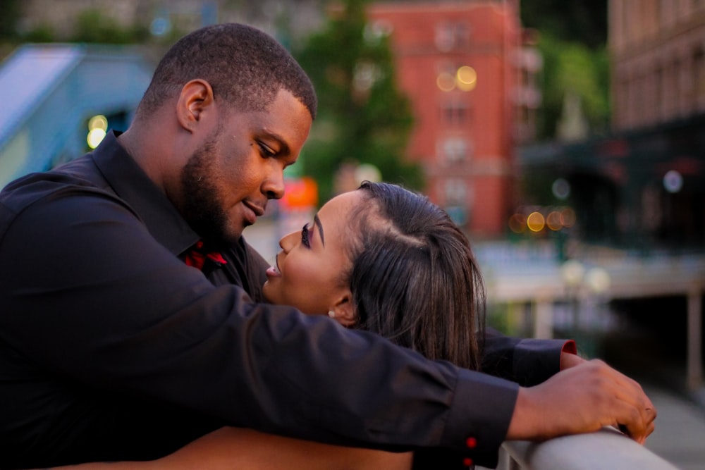 man in black long sleeve shirt kissing woman in black jacket