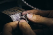 Artisan carefully polishing a delicate imitation diamond ring in a cozy workshop.