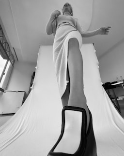 woman in white and black stripe dress sitting on white bed